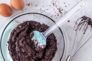 Preparing chocolate brownie batter in glass bowl.