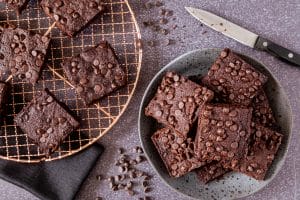 Chocolate chip brownies on cooling rack and plate.