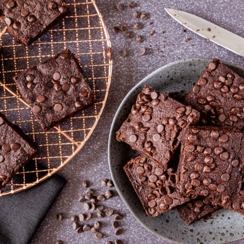 Chocolate chip brownies on cooling rack and plate.