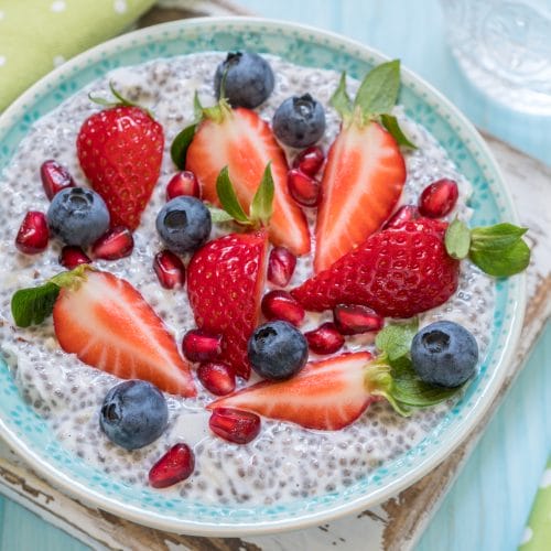 Fresh chia pudding with berries on wooden table.